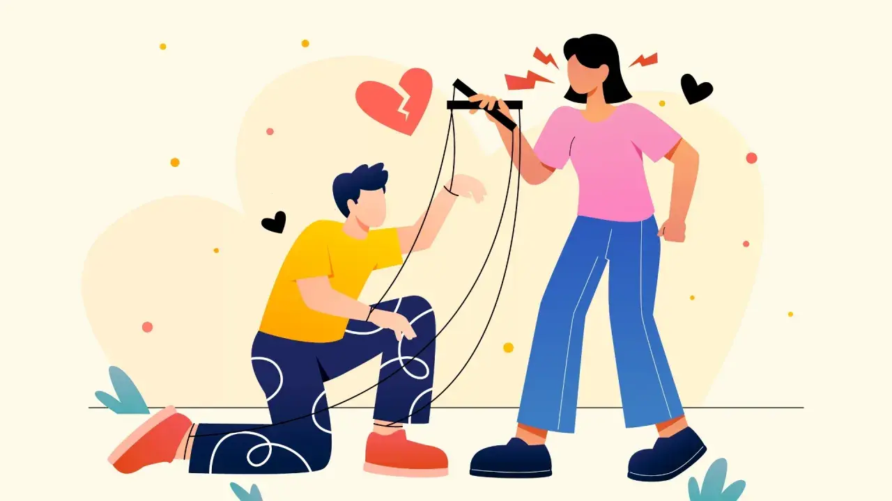 Una donna con la mania del controllo muove un uomo come un burattino, con un cuore spezzato sullo sfondo.