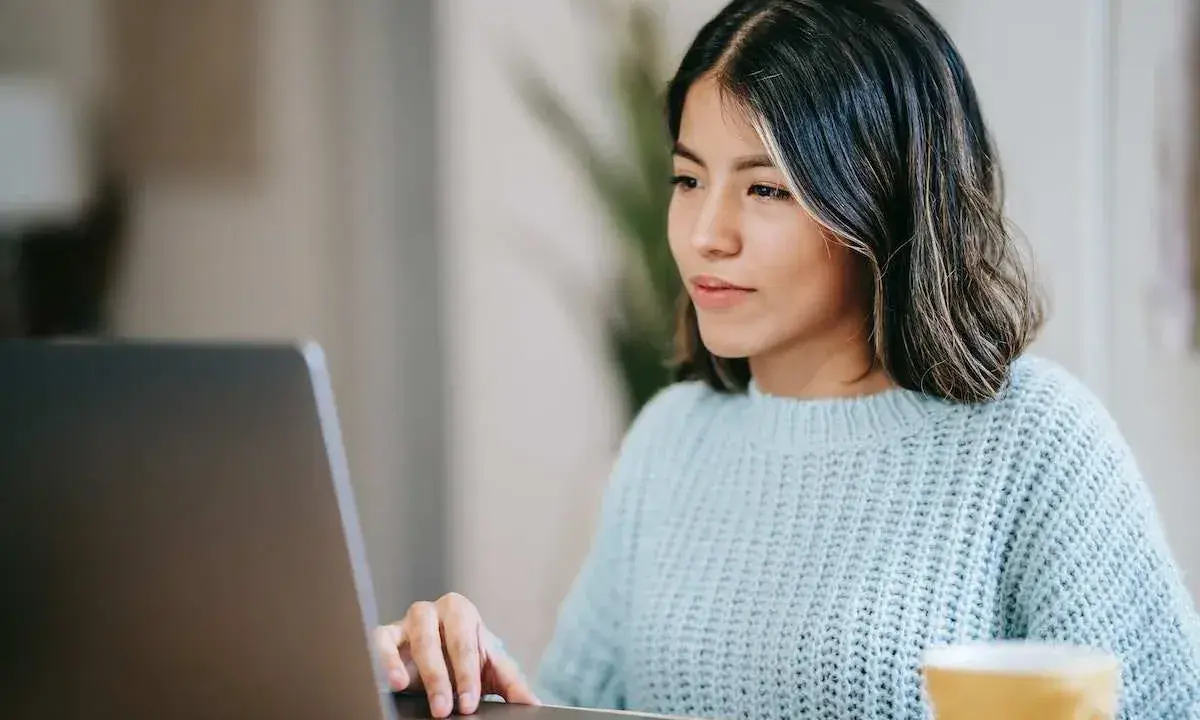 Ragazza concentrata al computer, forse sta usando il chat Tiscali per lavoro o svago.
