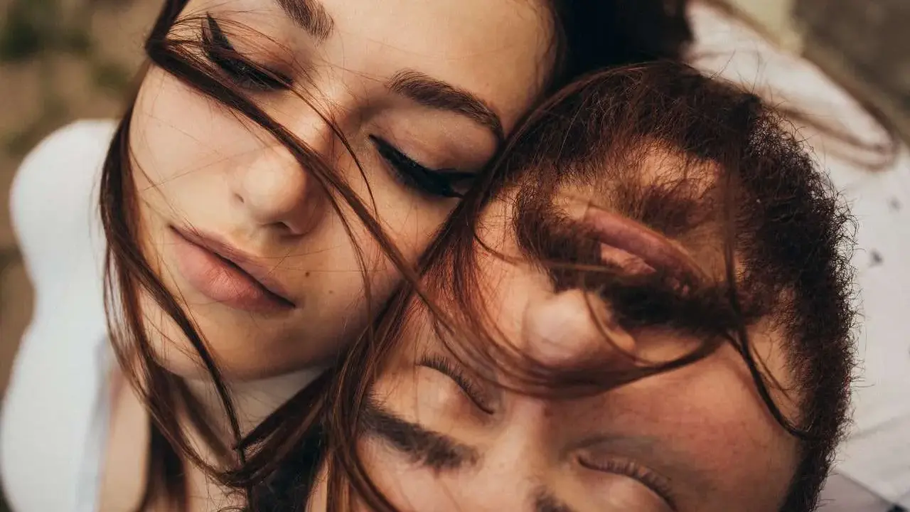 Un uomo e una donna vicini, occhi chiusi, capelli al vento. Le piaccio ma non risponde ai messaggi, un'attesa sospesa.