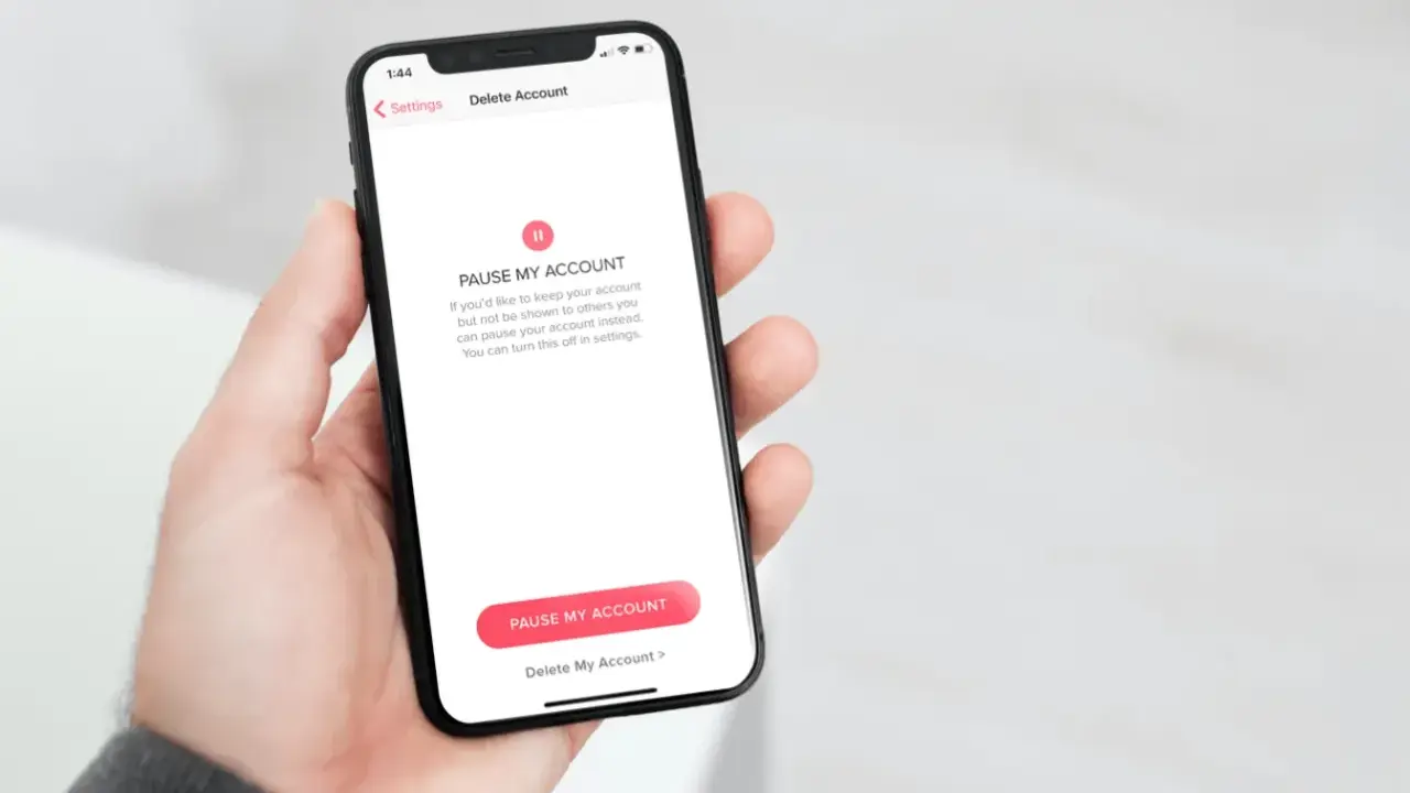 Schermata del telefono che mostra come disinstallare Tinder, con opzioni per mettere in pausa o eliminare l'account.