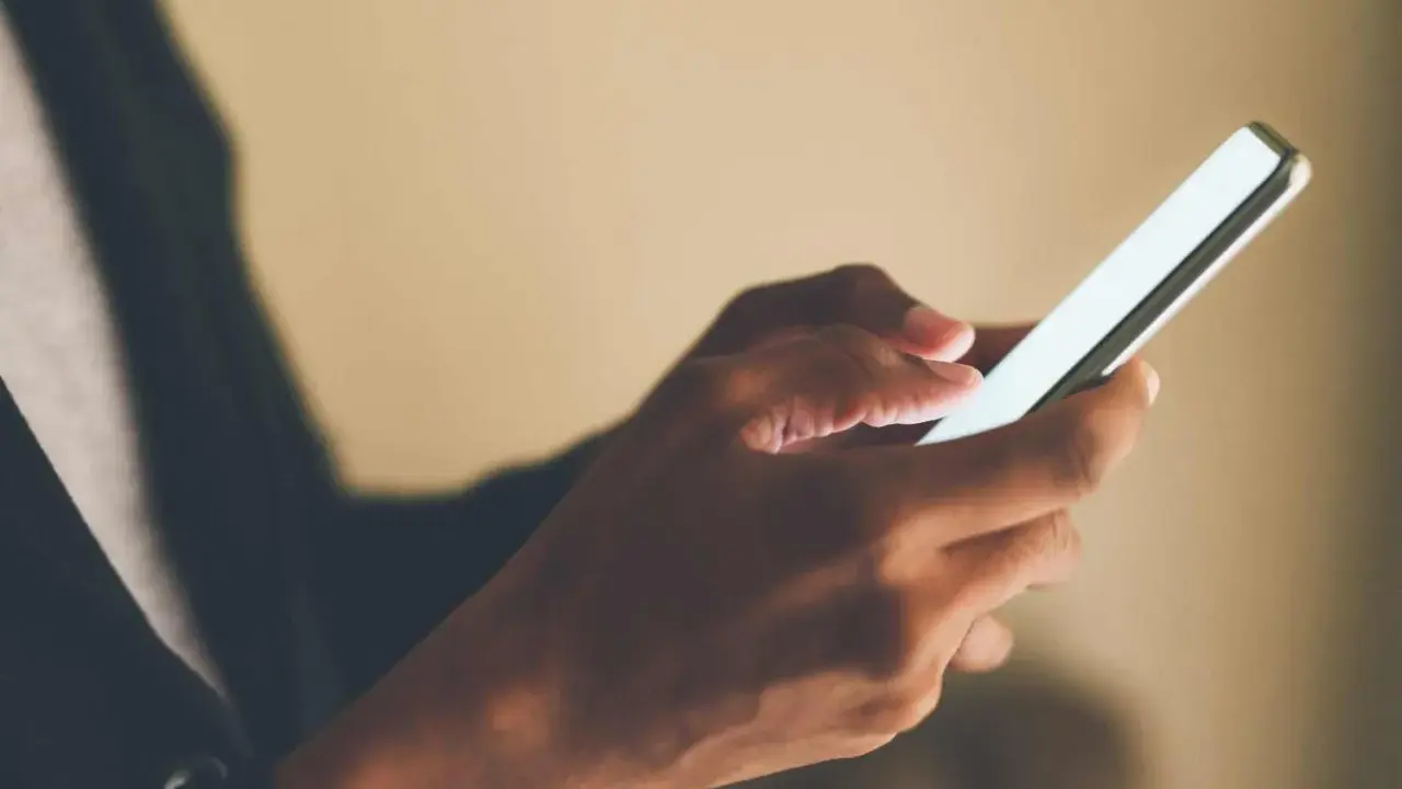 Mani che scorrono su uno smartphone, forse applicando la tattica di non rispondere ai messaggi per un po' di pace.
