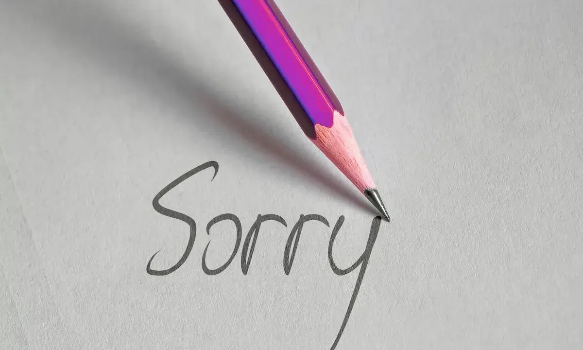 Matita rosa scrive "Sorry" su carta, un gesto per chiedere scusa per un comportamento sbagliato.