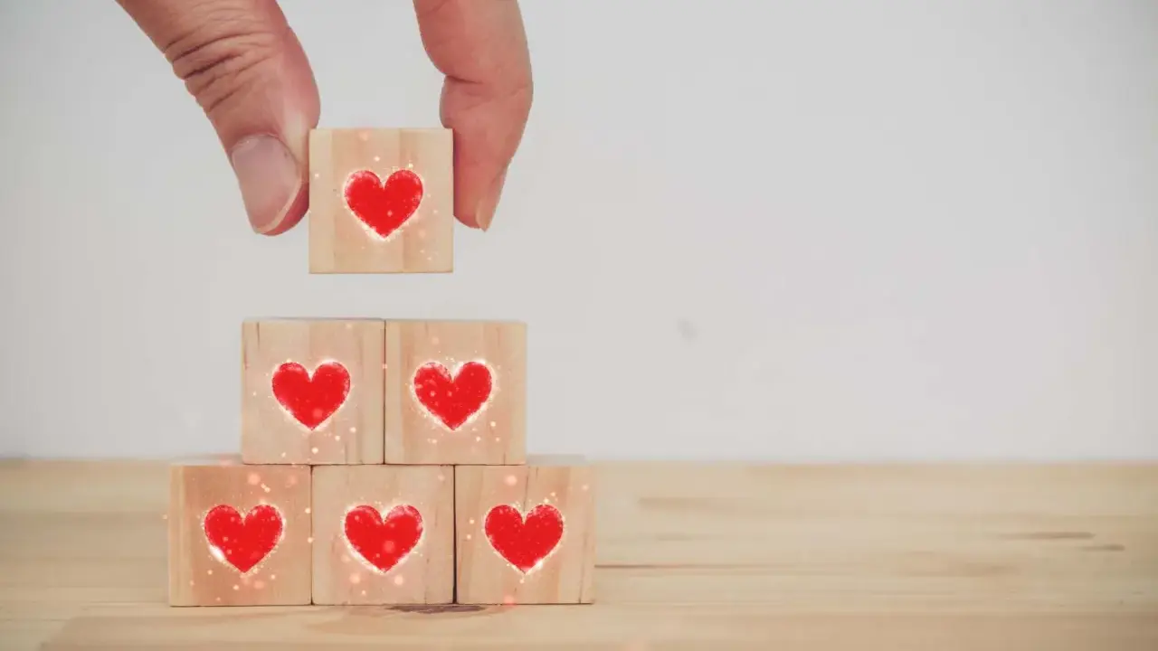 Costruire una relazione, un tassello alla volta, con il vero dating significato: cuori su cubi di legno.