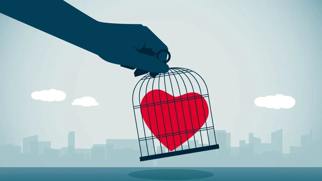 Mano che tiene una gabbia con un cuore rosso dentro, simbolo di messaggi da mandare a un narcisista per liberare il proprio sentimento.