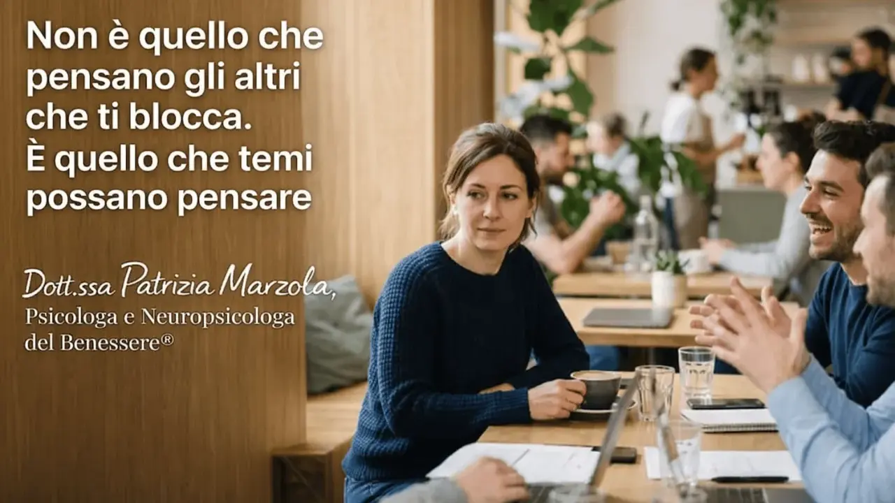 Una donna pensierosa in un caffè, mentre un uomo ride. Il testo recita: "Non è quello che pensano gli altri che ti blocca. È quello che temi possano pensare." La psicologa Patrizia Marzola ci ricorda che le nostre paure, non le opinioni altrui, ci limi...
