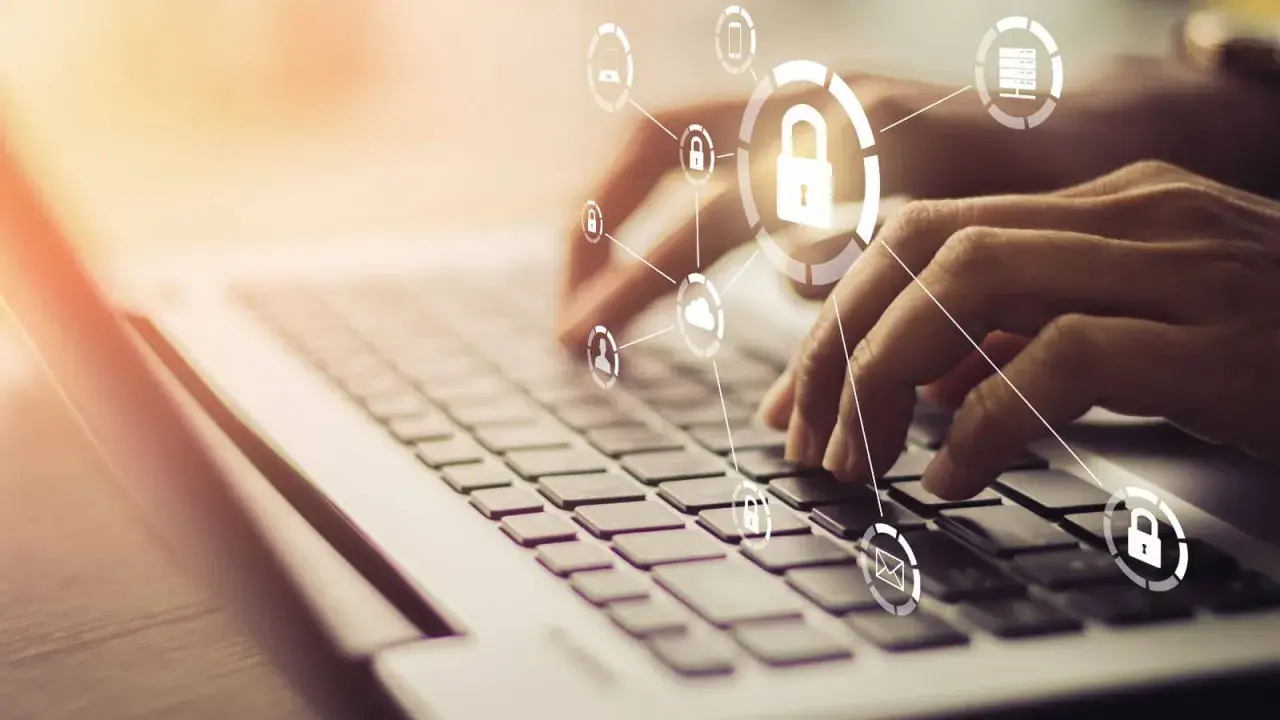 Mani che digitano su una tastiera, con icone di sicurezza e cloud che formano un **chat digit**al.