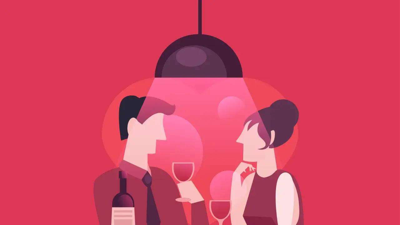Coppia a cena, lui non si fa sentire per tattica, lei attende pensierosa. Calice di vino e bottiglia sul tavolo.
