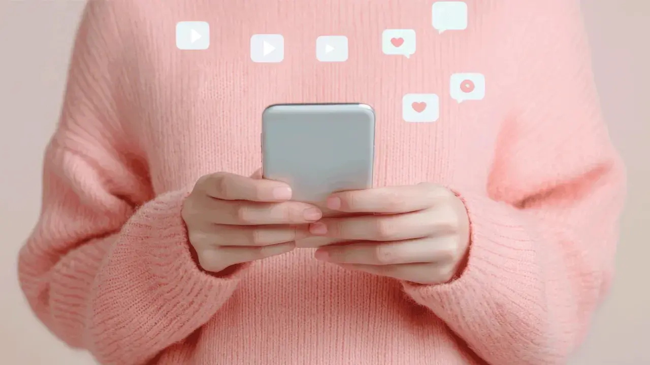 Mani con smartphone, icone di like e play fluttuano, evocando la psicologia di chi fa orbiting e cerca conferme digitali.