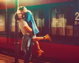 Un uomo solleva una donna in un bacio appassionato alla stazione. L'infatuazione significato è evidente nel loro abbraccio.