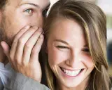 Un uomo le sussurra qualcosa all'orecchio, lei mi guarda negli occhi serio, ma un sorriso le increspa le labbra.