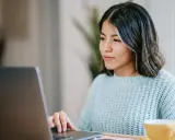 Ragazza concentrata al computer, forse sta usando il chat Tiscali per lavoro o svago.
