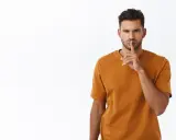 Uomo con dito sulle labbra, sguardo intenso. Sembra dire "shhh", forse perché un uomo non risponde ai messaggi.
