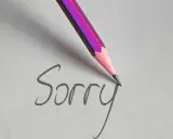 Matita rosa scrive "Sorry" su carta, un gesto per chiedere scusa per un comportamento sbagliato.