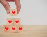 Costruire una relazione, un tassello alla volta, con il vero dating significato: cuori su cubi di legno.