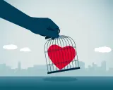 Mano che tiene una gabbia con un cuore rosso dentro, simbolo di messaggi da mandare a un narcisista per liberare il proprio sentimento.