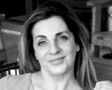 Ritratto in bianco e nero di una donna sorridente, con i capelli lunghi e mossi. "Ciao, come stai?" è una domanda inutile se il tuo sguardo è così sereno.