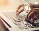 Mani che digitano su una tastiera, con icone di sicurezza e cloud che formano un **chat digit**al.