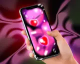 Mano che tiene uno smartphone con icone a forma di cuore, forse per un'app di f.dating. Sfondo sfumato viola e verde.