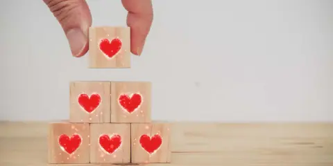 Costruire una relazione, un tassello alla volta, con il vero dating significato: cuori su cubi di legno.