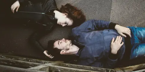 Coppia sdraiata, sguardi intensi. Una relazione tossica può diventare sana, un nuovo inizio.