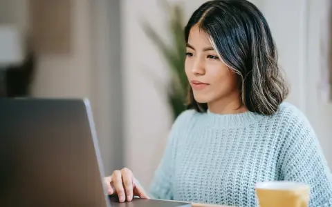 Ragazza concentrata al computer, forse sta usando il chat Tiscali per lavoro o svago.