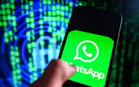 Un dito tocca lo schermo di uno smartphone con il logo WhatsApp, simbolo di cosa è una chat moderna. Sullo sfondo, un lucchetto digitale e codice binario suggeriscono sicurezza e comunicazione.