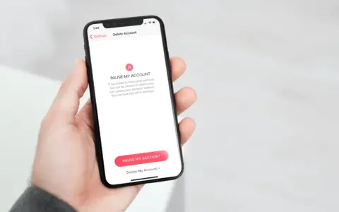 Schermata del telefono che mostra come disinstallare Tinder, con opzioni per mettere in pausa o eliminare l'account.