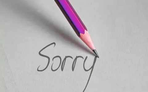 Matita rosa scrive "Sorry" su carta, un gesto per chiedere scusa per un comportamento sbagliato.