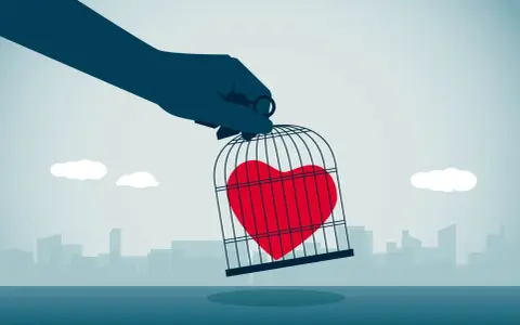 Mano che tiene una gabbia con un cuore rosso dentro, simbolo di messaggi da mandare a un narcisista per liberare il proprio sentimento.