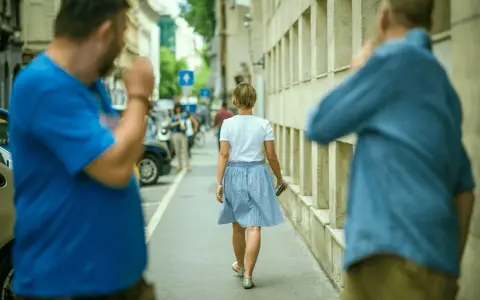 Uomo in strada fa gesti volgari a donna, un esempio di catcalling reato.
