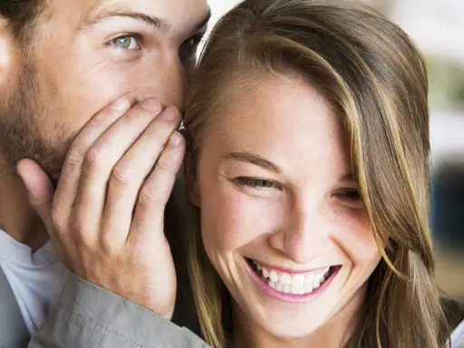 Un uomo le sussurra qualcosa all'orecchio, lei mi guarda negli occhi serio, ma un sorriso le increspa le labbra.