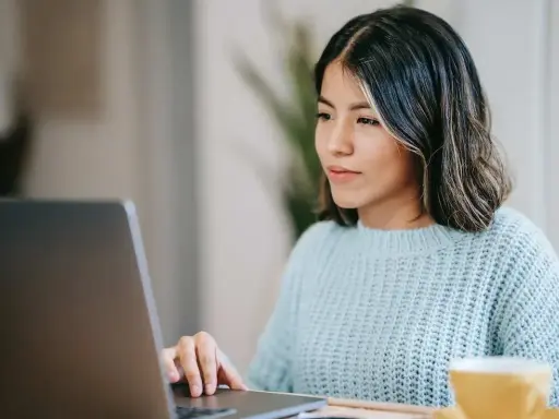 Ragazza concentrata al computer, forse sta usando il chat Tiscali per lavoro o svago.