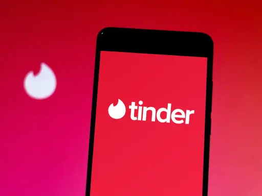 Smartphone con logo Tinder. Inizia un nuovo chat insieme, sperando in un match.