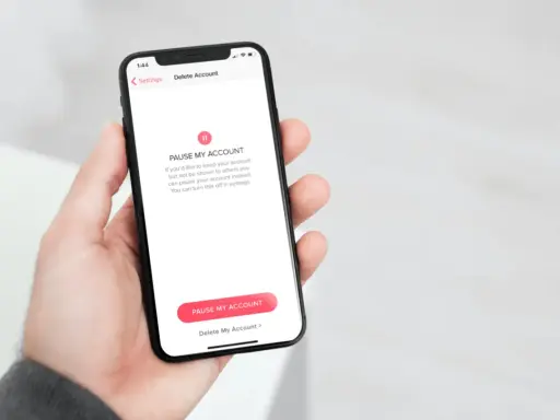Schermata del telefono che mostra come disinstallare Tinder, con opzioni per mettere in pausa o eliminare l'account.
