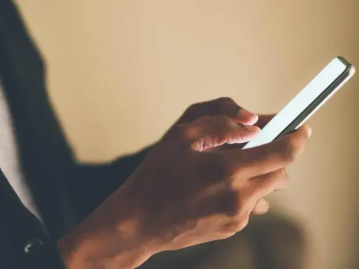 Mani che scorrono su uno smartphone, forse applicando la tattica di non rispondere ai messaggi per un po' di pace.