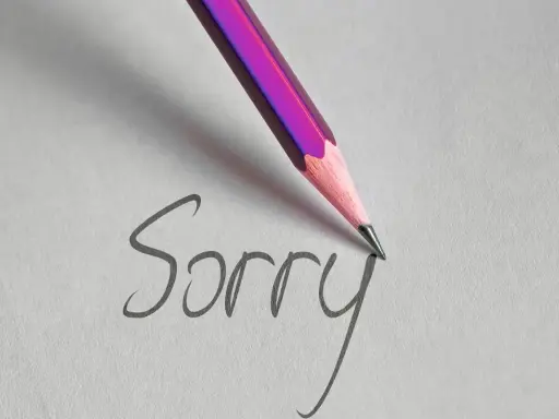 Matita rosa scrive "Sorry" su carta, un gesto per chiedere scusa per un comportamento sbagliato.