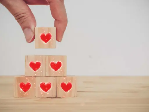 Costruire una relazione, un tassello alla volta, con il vero dating significato: cuori su cubi di legno.