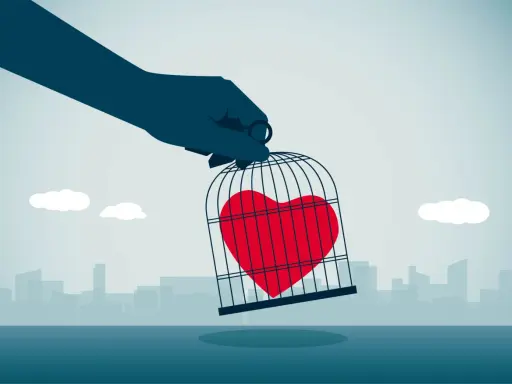 Mano che tiene una gabbia con un cuore rosso dentro, simbolo di messaggi da mandare a un narcisista per liberare il proprio sentimento.