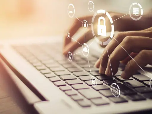 Mani che digitano su una tastiera, con icone di sicurezza e cloud che formano un **chat digit**al.