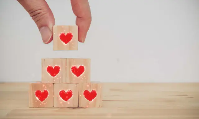Costruire una relazione, un tassello alla volta, con il vero dating significato: cuori su cubi di legno.