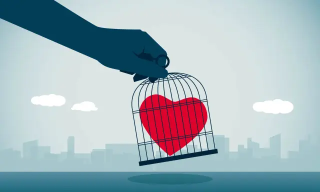 Mano che tiene una gabbia con un cuore rosso dentro, simbolo di messaggi da mandare a un narcisista per liberare il proprio sentimento.