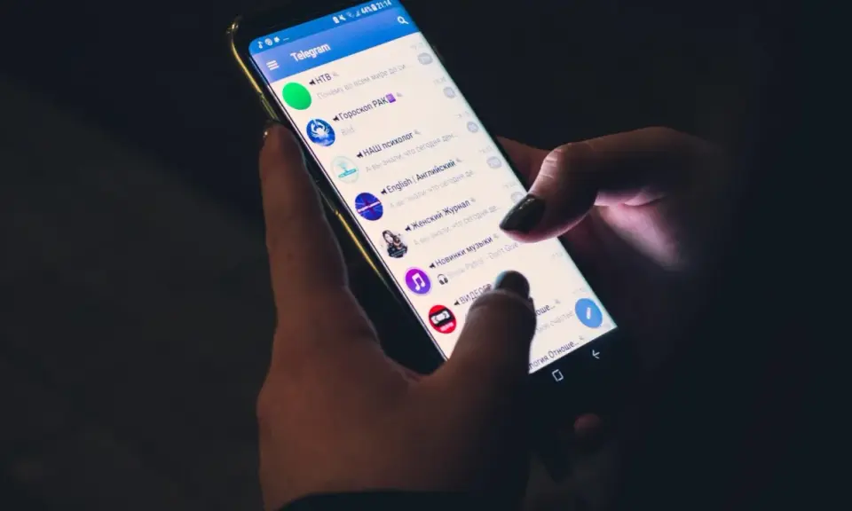 Mani che scorrono su Telegram, mostrando cinque chat attive: notizie, oroscopo, psicologia, inglese e musica.