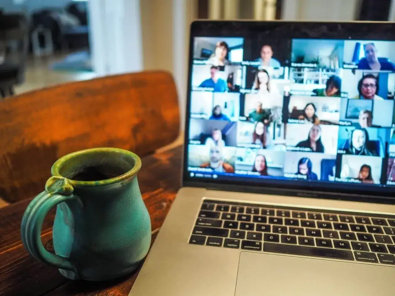 Tazza di caffè accanto a un laptop con una riunione di digochat in corso.