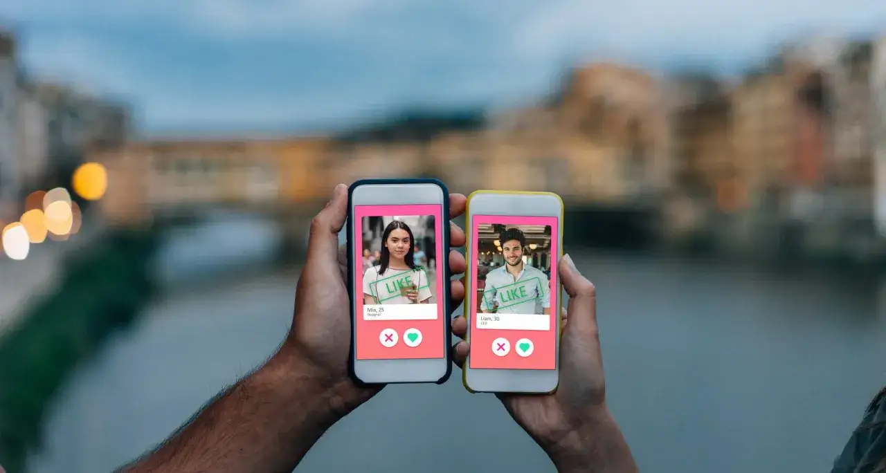 Due mani tengono due smartphone con profili di app di incontri. Uno mostra Mia, l'altro Liam. Forse un nuovo inizio su FriendScout.