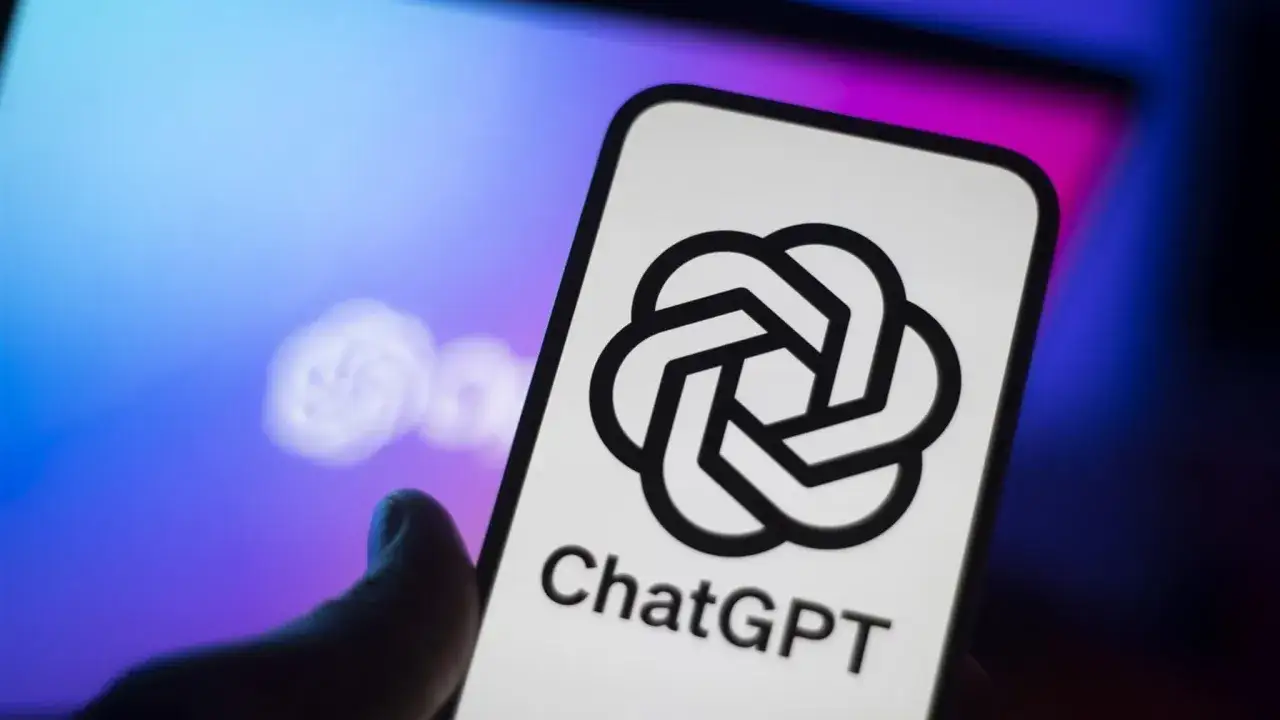 Logo di ChatGPT su uno smartphone, con un laptop sfocato sullo sfondo. Il futuro del chat digit &egrave; qui.