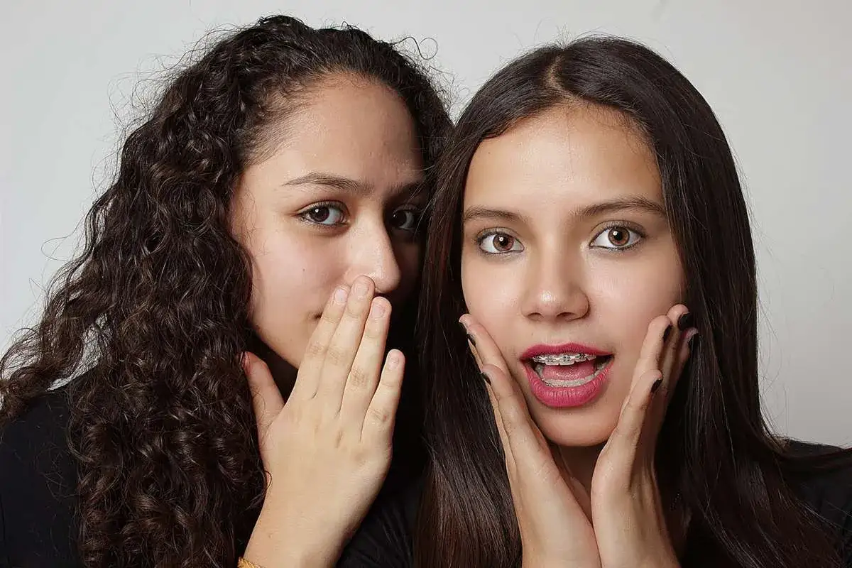 Due ragazze si sussurrano segreti. Una con capelli ricci, l'altra con apparecchio. Chiss&agrave; cosa scrivere a un ragazzo che ti piace!