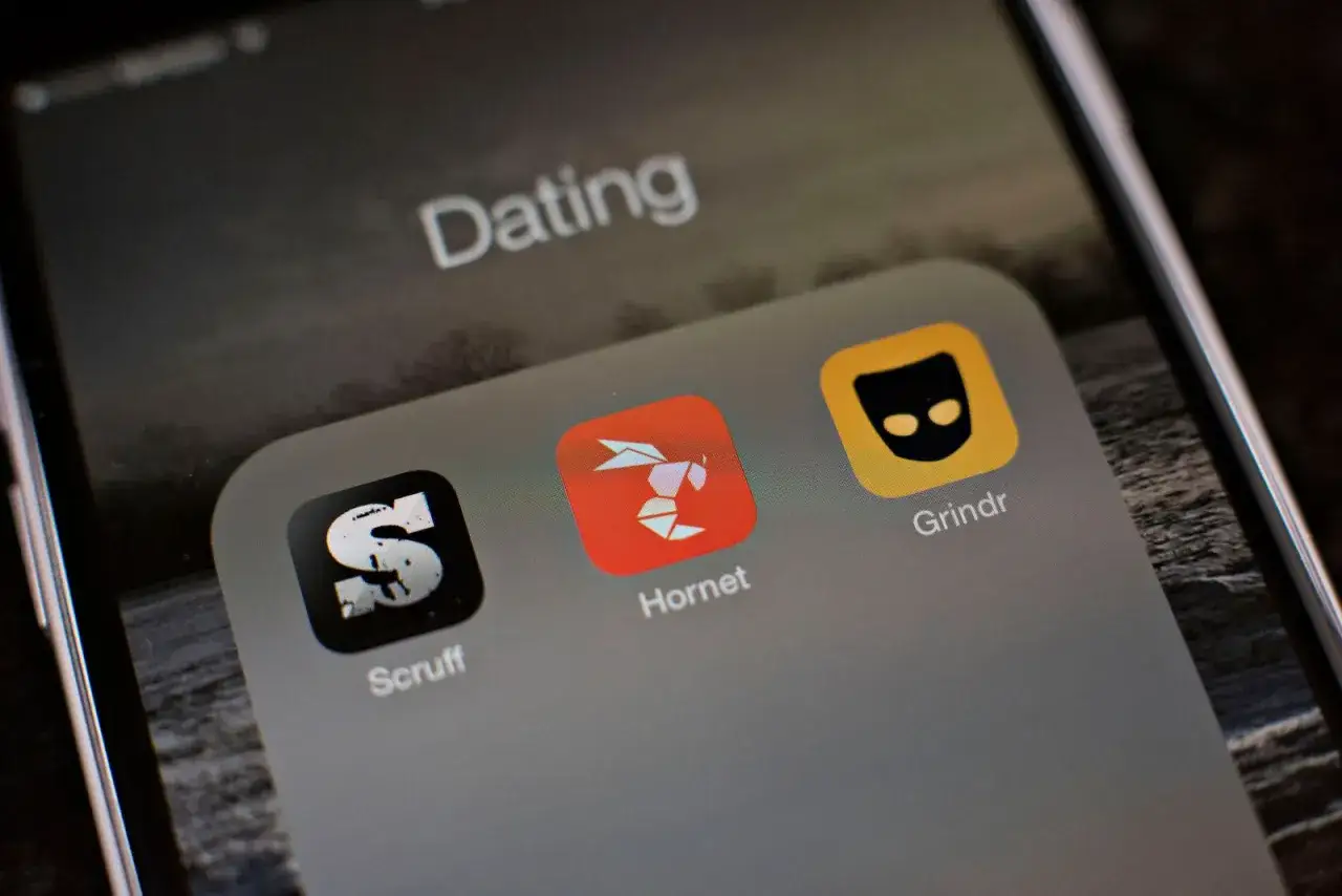 Schermata di un telefono con icone di app per incontri gay: Scruff, Hornet e Grindr.