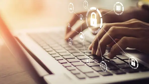 Mani che digitano su una tastiera, con icone di sicurezza e cloud che formano un **chat digit**al.